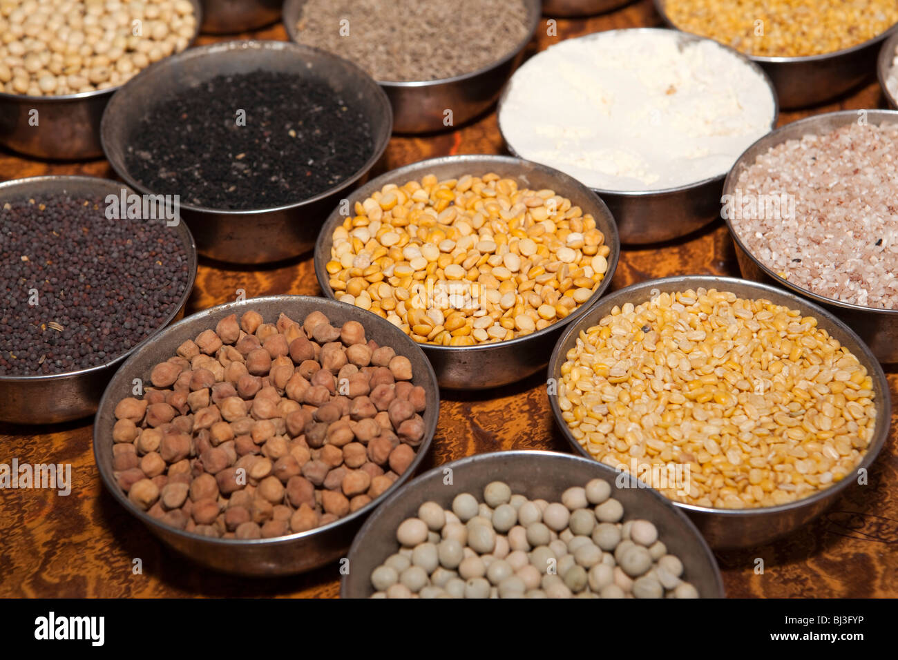 India Kerala, Calicut, Kozhikode, Halwa Bazaar, piastre di essiccato differenti campioni di impulsi sul display in grossista alimentare Foto Stock