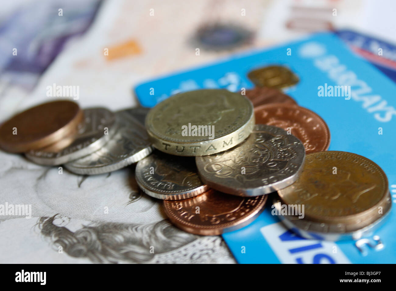 Close up della sterlina monete sulla parte superiore delle carte bancarie e sterling note Foto Stock