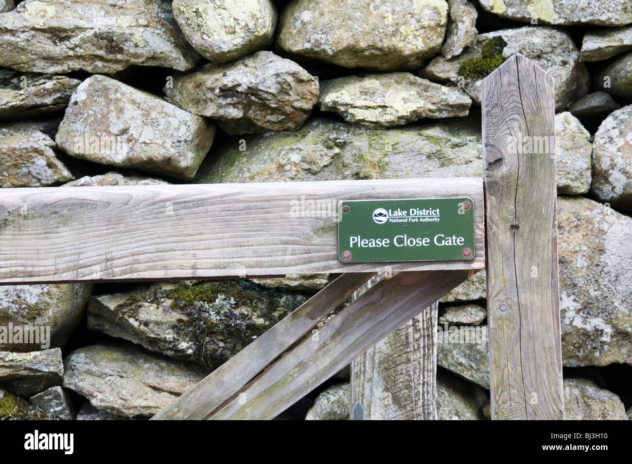 Si prega di chiudere la porta segno sul cancello di legno nel Lake District inglese Foto Stock