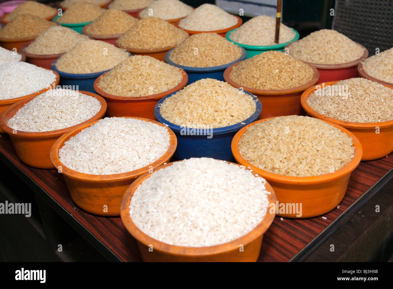 India Kerala, Calicut, Kozhikode, Halwa Bazaar, piastre di diversi campioni di riso sul display in grossista alimentare Foto Stock