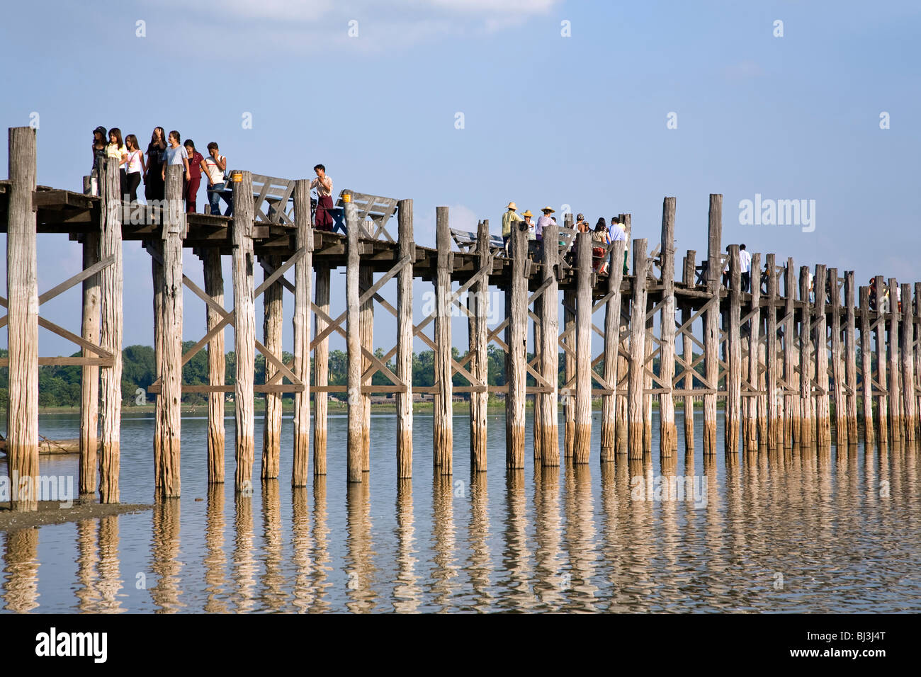 Popolo birmano attraversando U Bein's Bridge. Lago Taungthaman. Amarapura. Myanmar Foto Stock