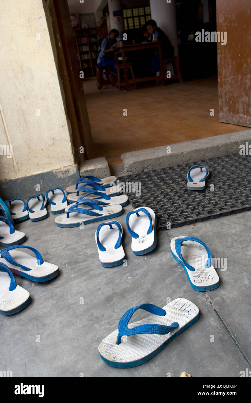 Scarpe fuori della porta della libreria al Villaggio dei Bambini Tibetani, Chauntra, India Foto Stock