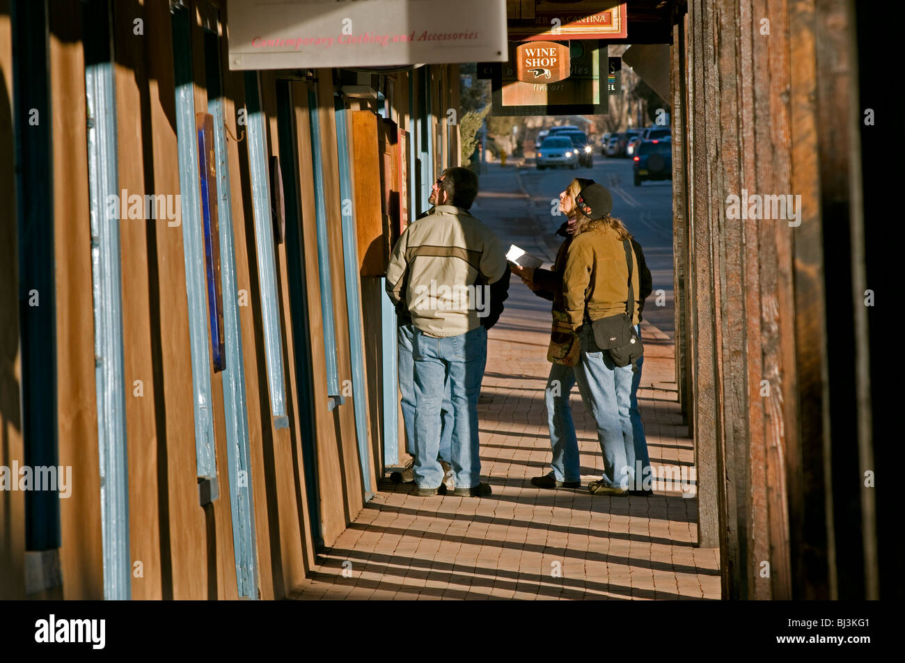 Il gruppo di quattro turisti guardando il menu del ristorante e la guida di lettura sul lungomare nel centro di Santa Fe, NM Foto Stock