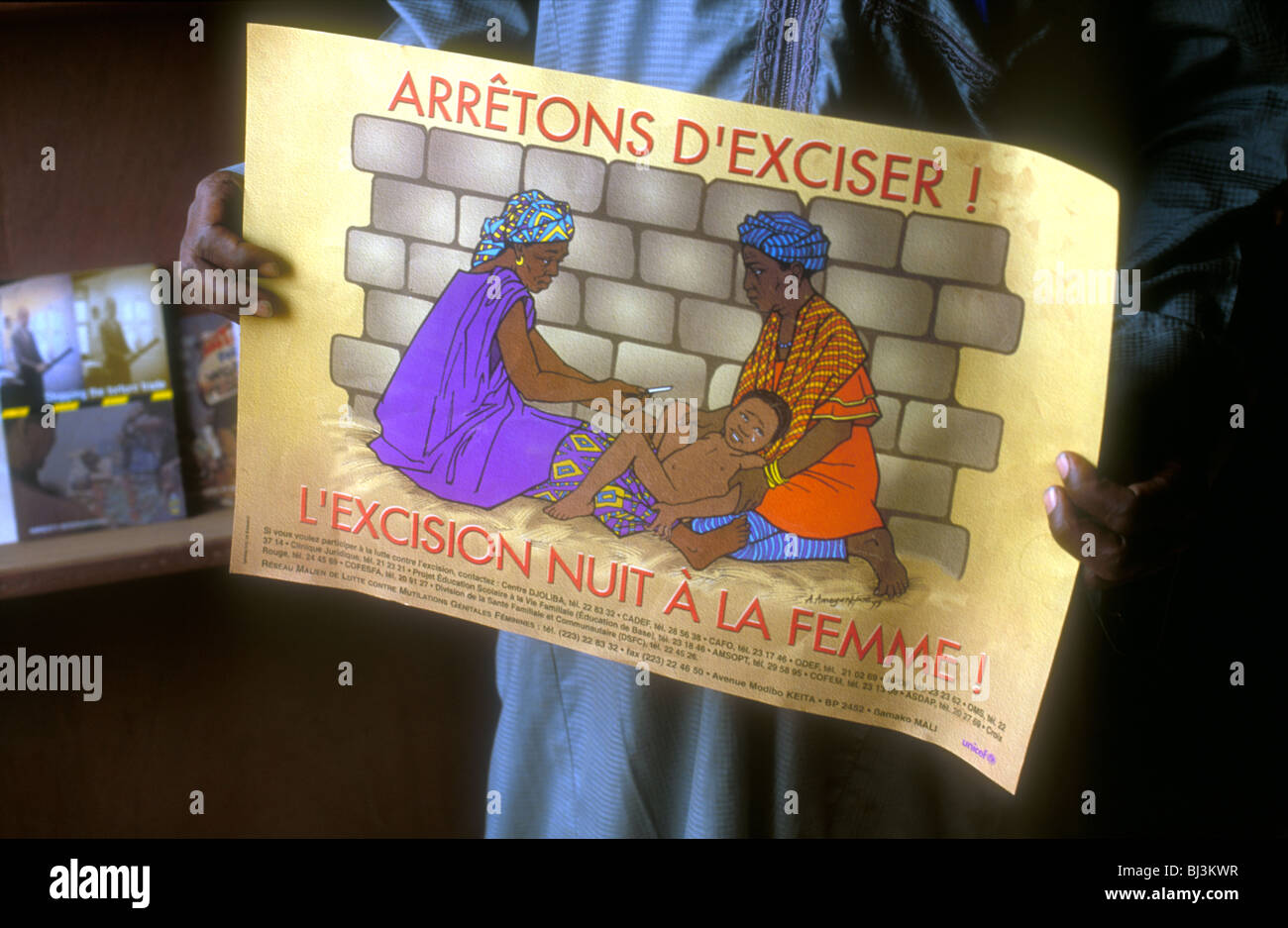Un Amnesty International lavoratore di Bamako, in Mali, tenendo in mano un poster sulla campagna contro le mutilazioni genitali femminili. Foto Stock