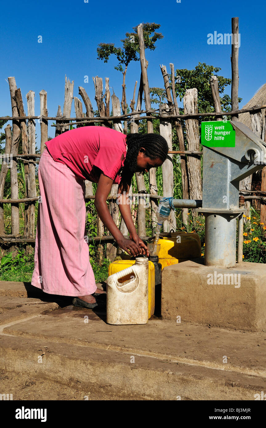 Donna etiope il pompaggio di acqua potabile a una nuova pompa integrata, Rift Valley, Oromia, Etiopia, Africa Foto Stock