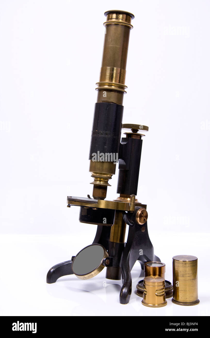 In ottone antico microscopio con lenti addizionali contro uno sfondo bianco Foto Stock