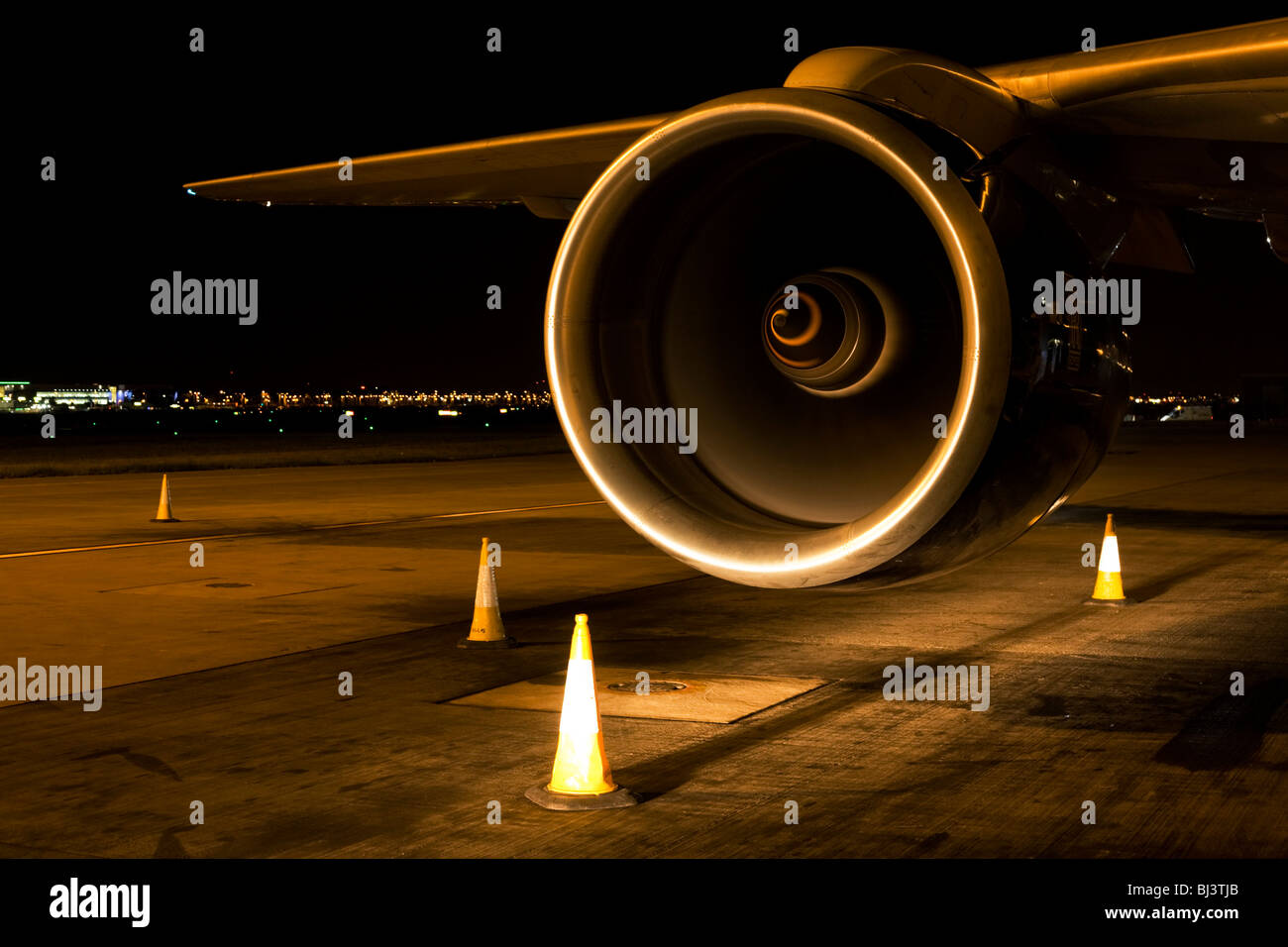 British Airways Boeing aeromobili jet motore evidenziato dai fari di un aerodromo di Heathrow veicolo. Foto Stock