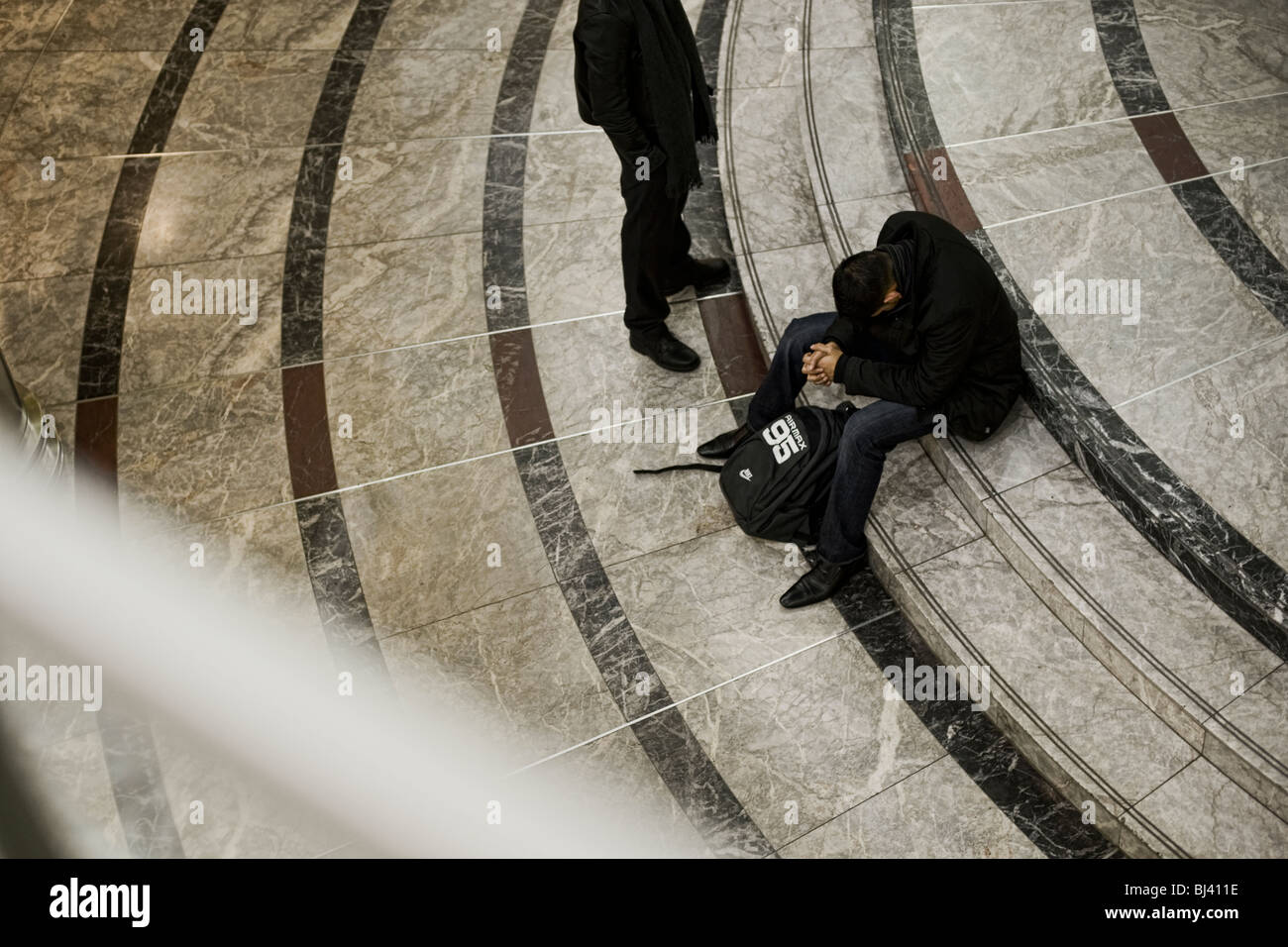 Terrorista o shopper? Due uomini in un centro commerciale con uno zaino, una testa piegata come se pregando in Canary Warf Foto Stock