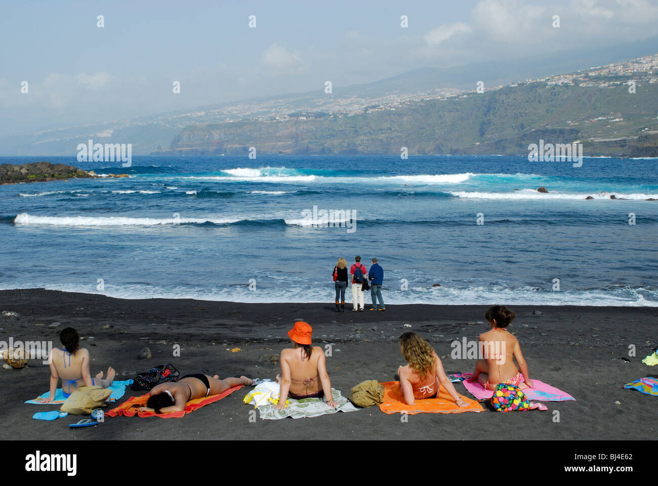 Spagna Isole Canarie Tenerife Puerto de la Cruz, Playa Martianez, giovani sulla spiaggia Foto Stock