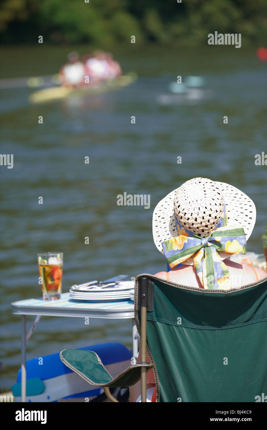 Spettatore guardando una gara presso il Royal Henley Regatta dal lato del fiume Foto Stock