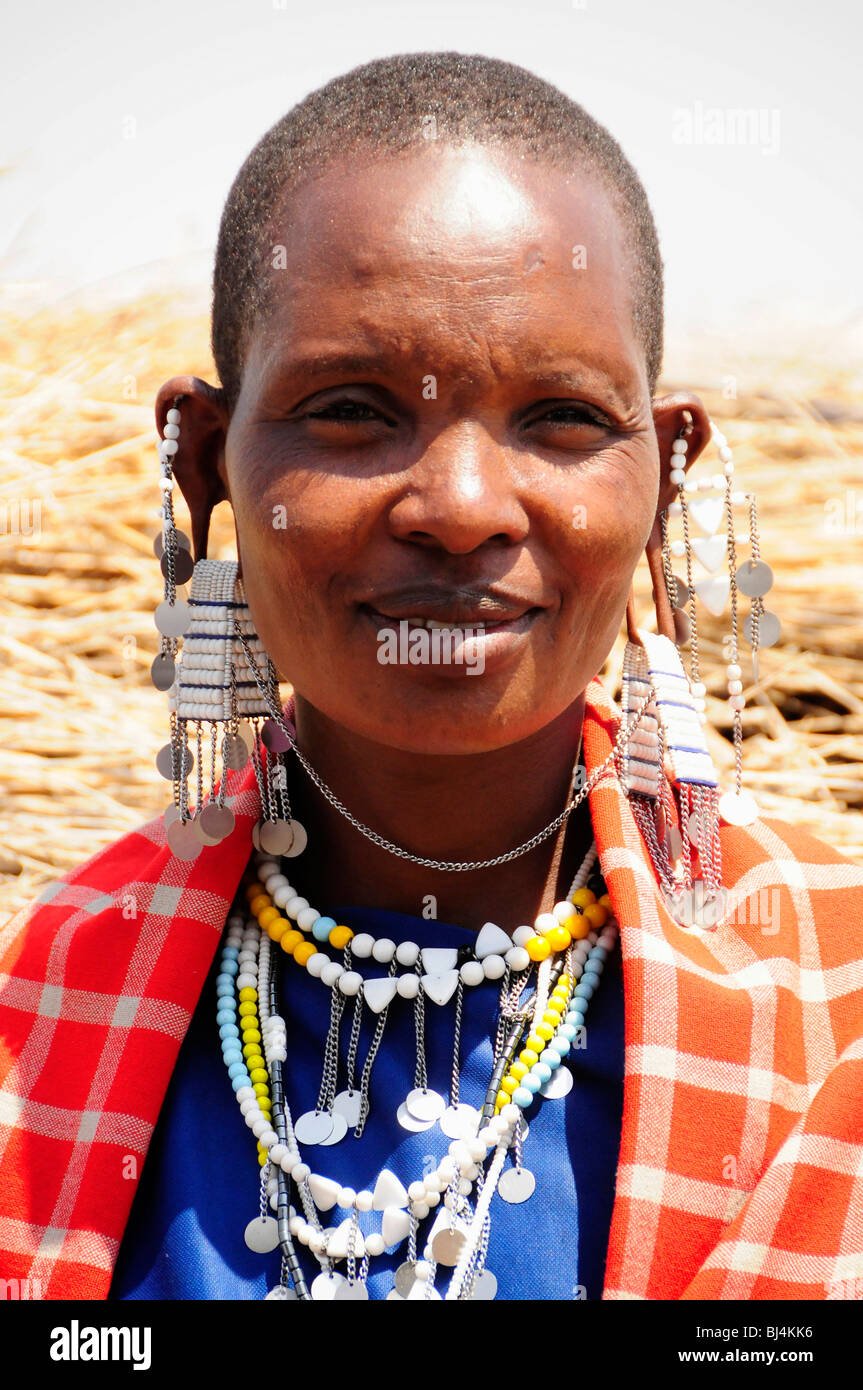 Masai donna con copricapo tradizionale nel villaggio Kiloki, Serengeti, Tanzania Africa Foto Stock