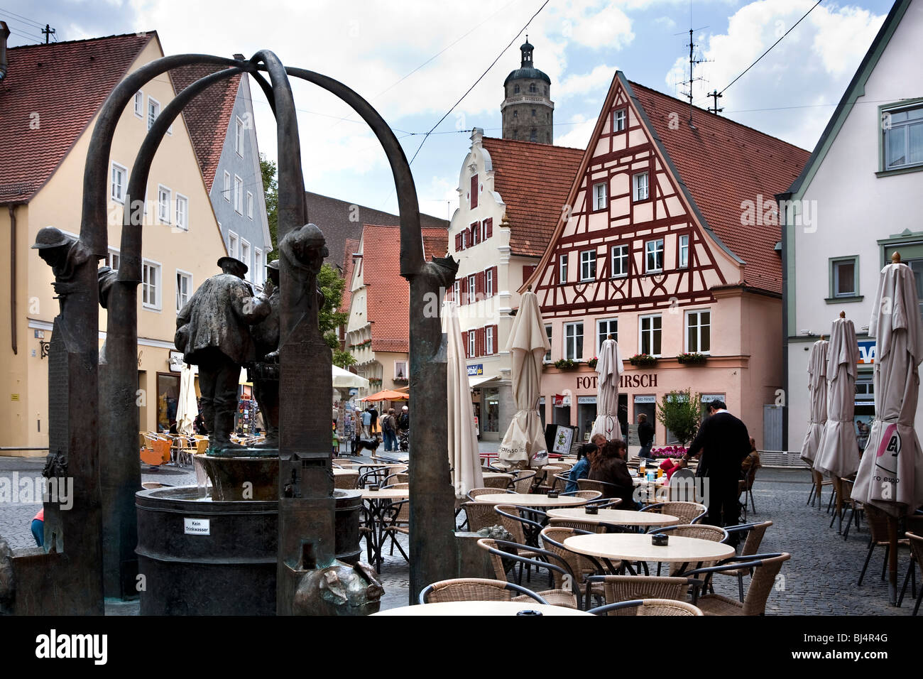 Fontana ornata con sculture e area all'aperto del ristorante sulla strada, Nordlingen, Baviera, Germania Foto Stock