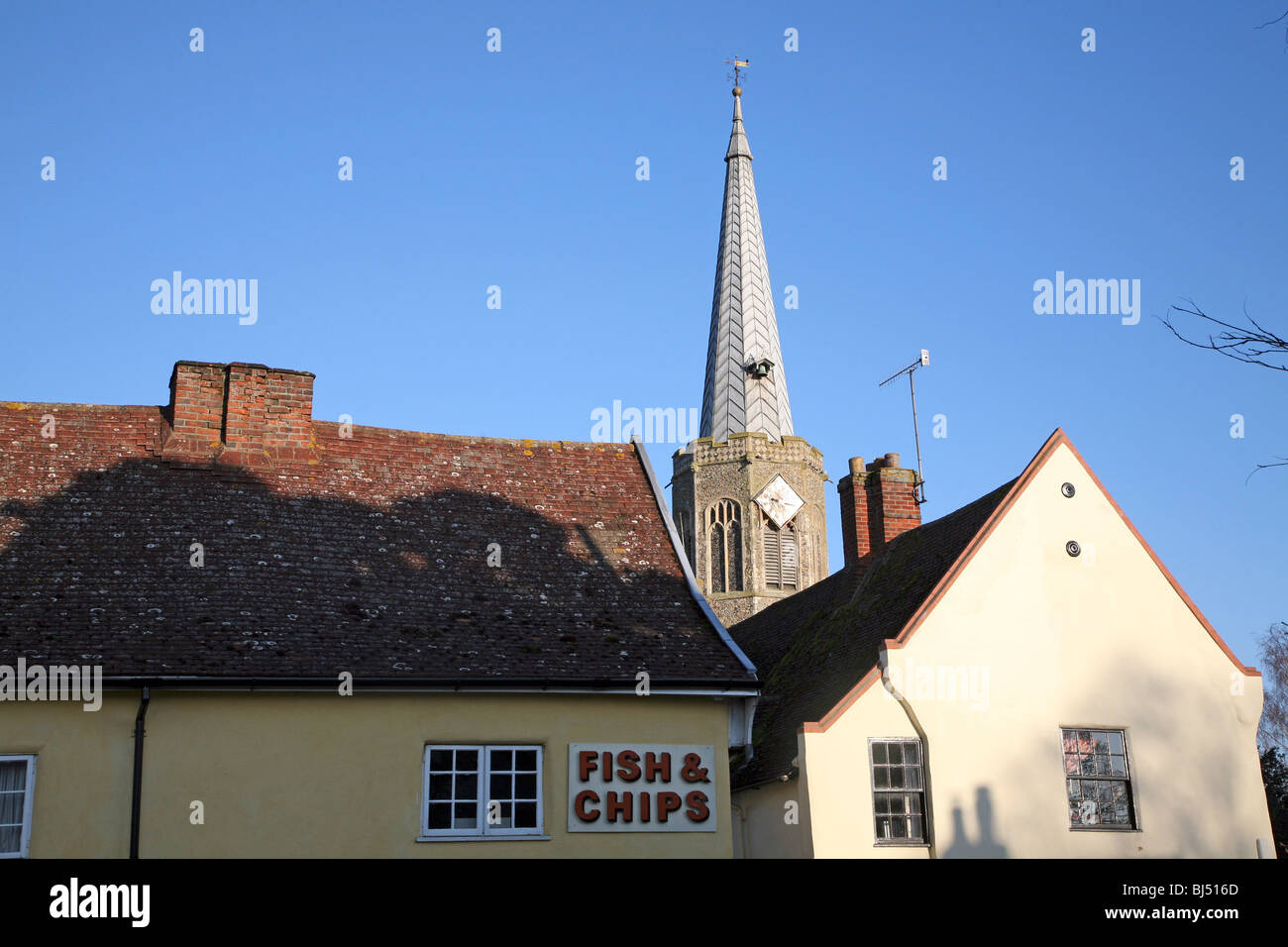 Chiesa guglia pesce e chip shop segno tetti Wickham Market Suffolk in Inghilterra Foto Stock
