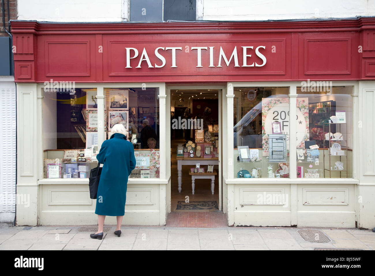 Tempi passati shop esterno Colchester Essex Inghilterra, donna cercando in wondow Foto Stock