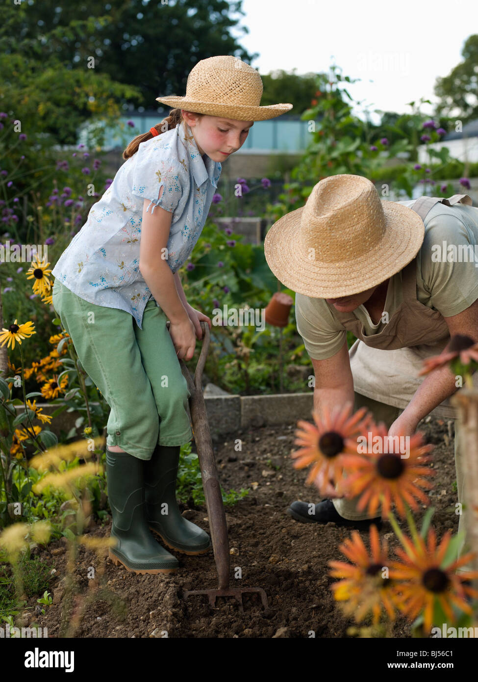 Una giovane ragazza e donna lavorare in allotment Foto Stock