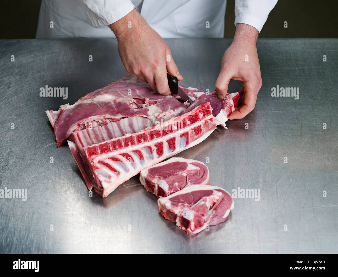 Un macellaio il taglio di carne Foto Stock