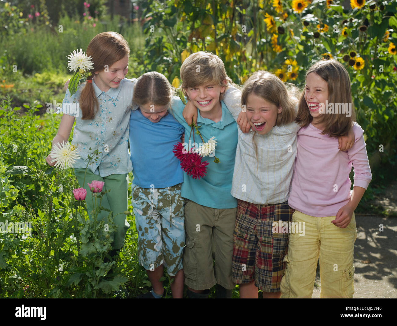 Gli amici di sorridere insieme in un giardino Foto Stock