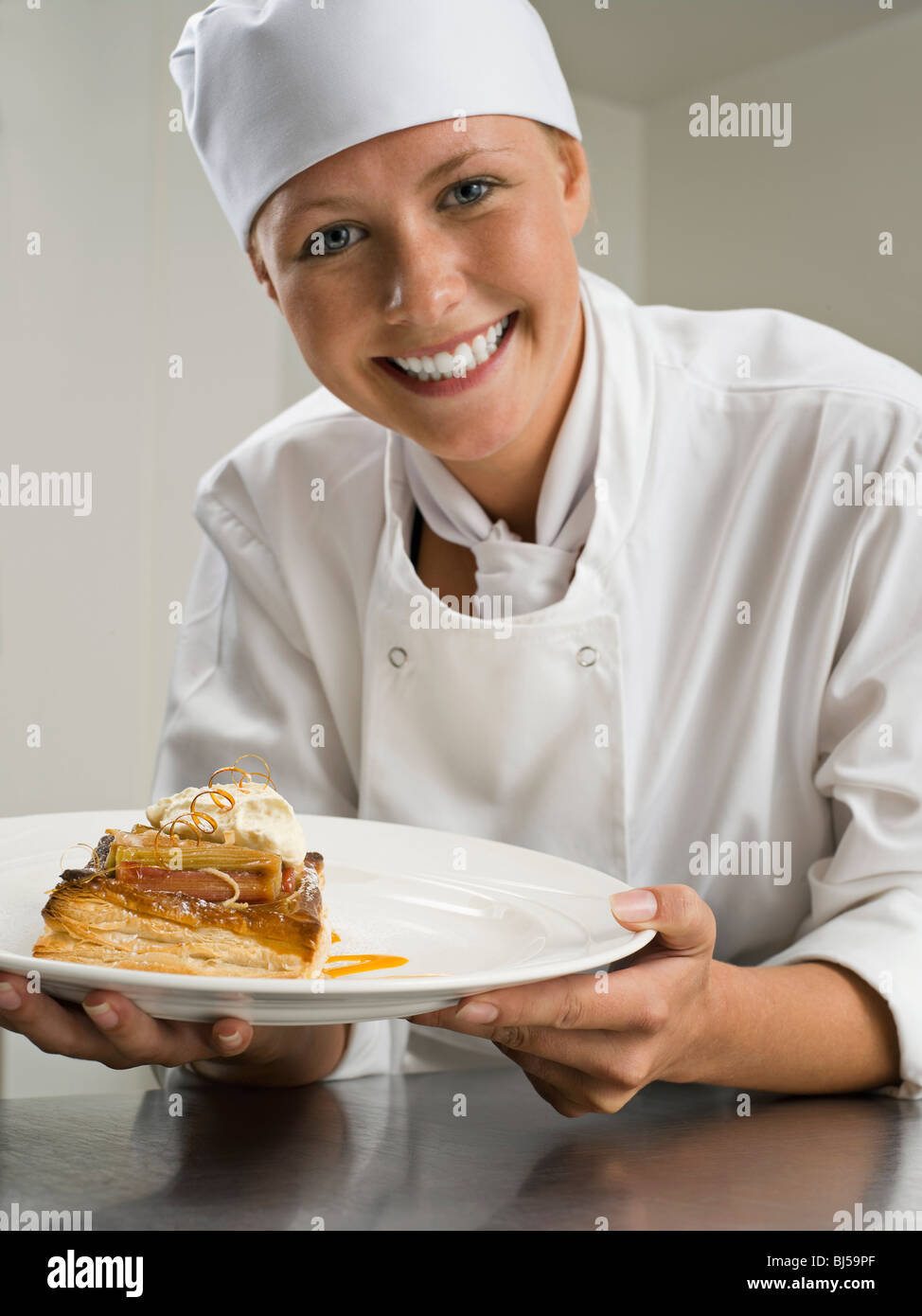 Una femmina di chef tenendo un deserto di pasticceria Foto Stock