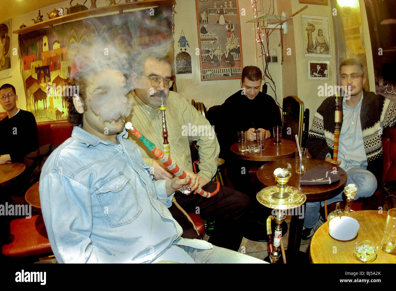 PARIGI, Cafe, Francia - uomini arabi che fumano tradizionale Pipe Hookah in 'Oum Kalthoum' Paris Coffee Shop Group in pub Foto Stock