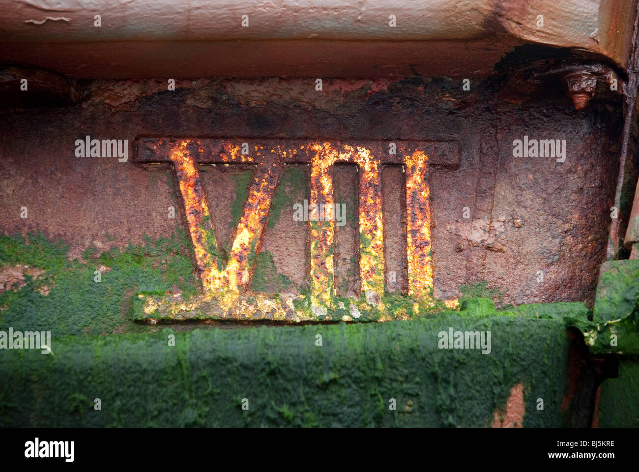 Il numero 8 in numeri romani sul lato di un arrugginito lo scafo dell'imbarcazione. Foto Stock