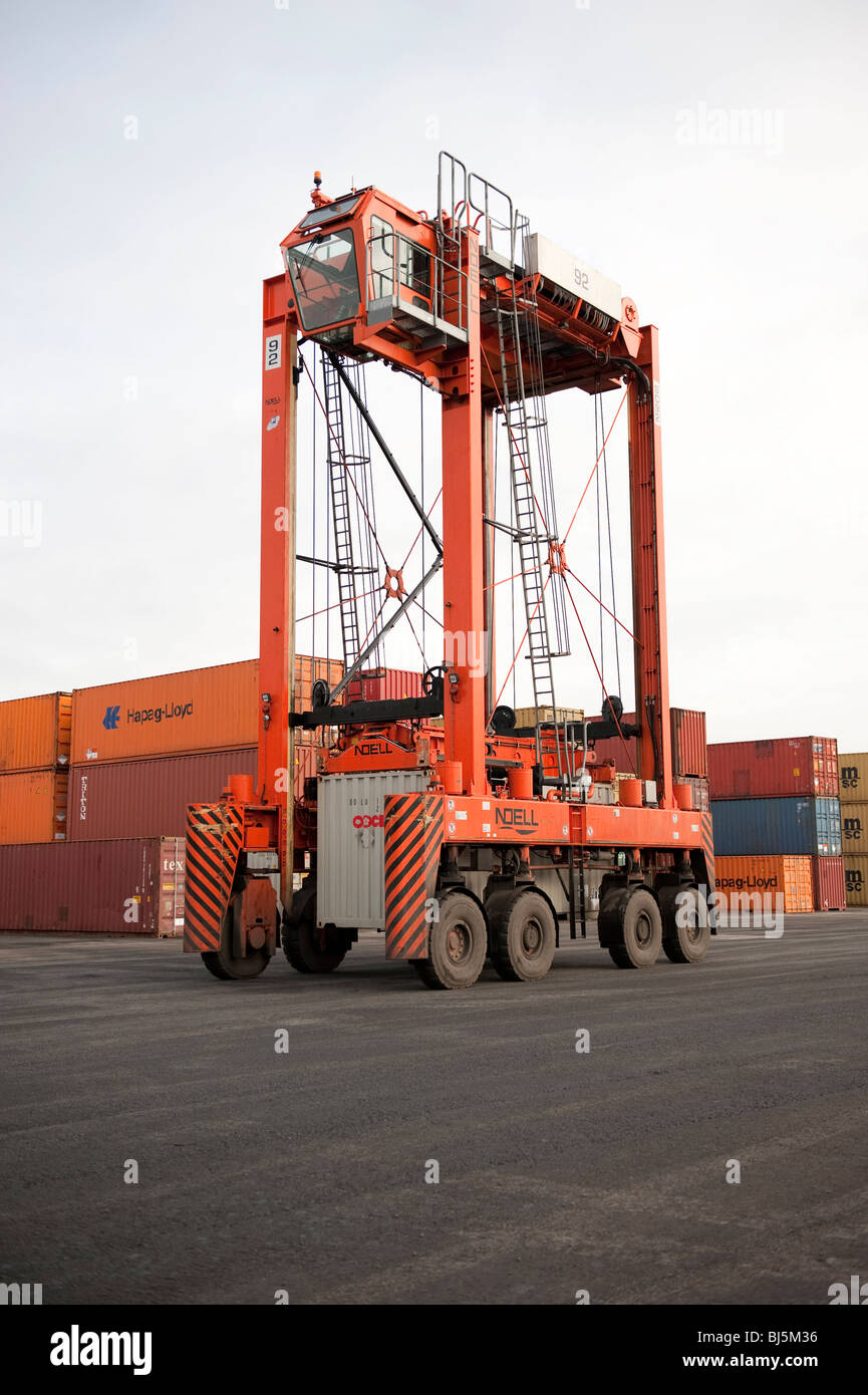 Orange Straddle Carrier gru per il sollevamento di container delle navi in porto Foto Stock