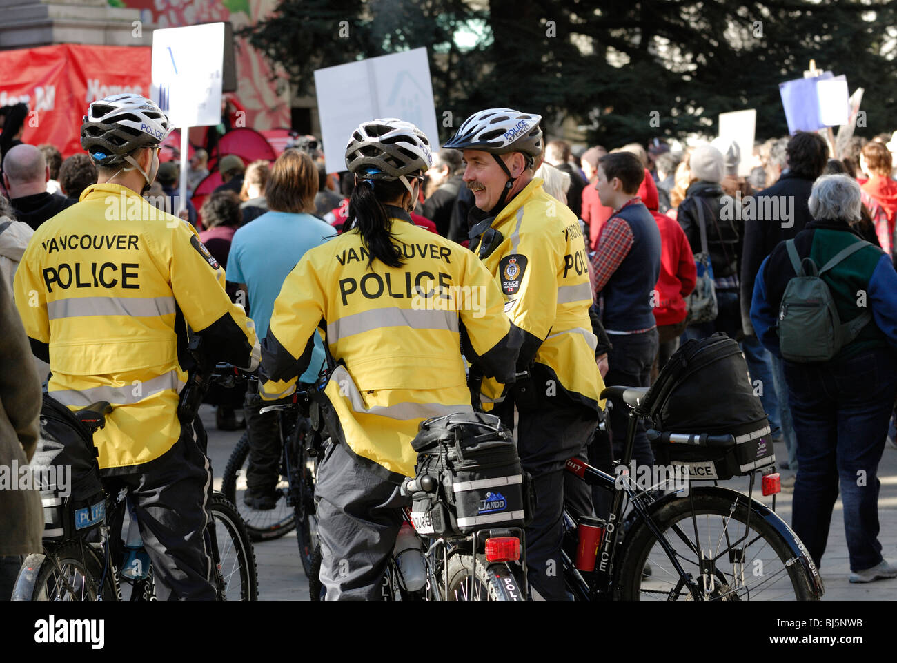Vancouver della polizia in città sulle biciclette, mantenendo un occhio sui manifestanti. Foto Stock
