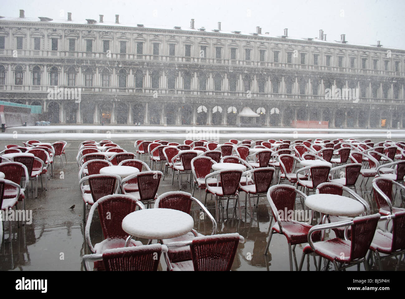 Cafe i tavoli e le sedie in una tempesta di neve, Piazza San Marco, Venezia, Italia Foto Stock