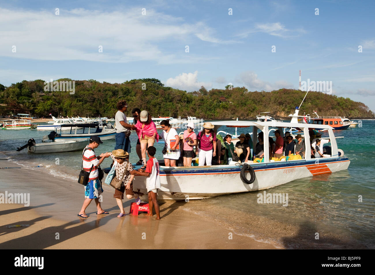 Indonesia, Bali, Padangbai, i turisti giapponesi in partenza giorno di viaggio barca sulla spiaggia Foto Stock
