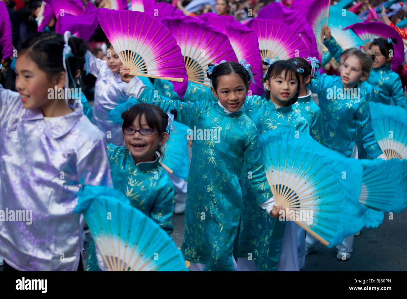 I bambini vestiti in cinese brocade abiti eseguire con ventole colorate nel nuovo anno cinese Parade, San Francisco, California. Foto Stock
