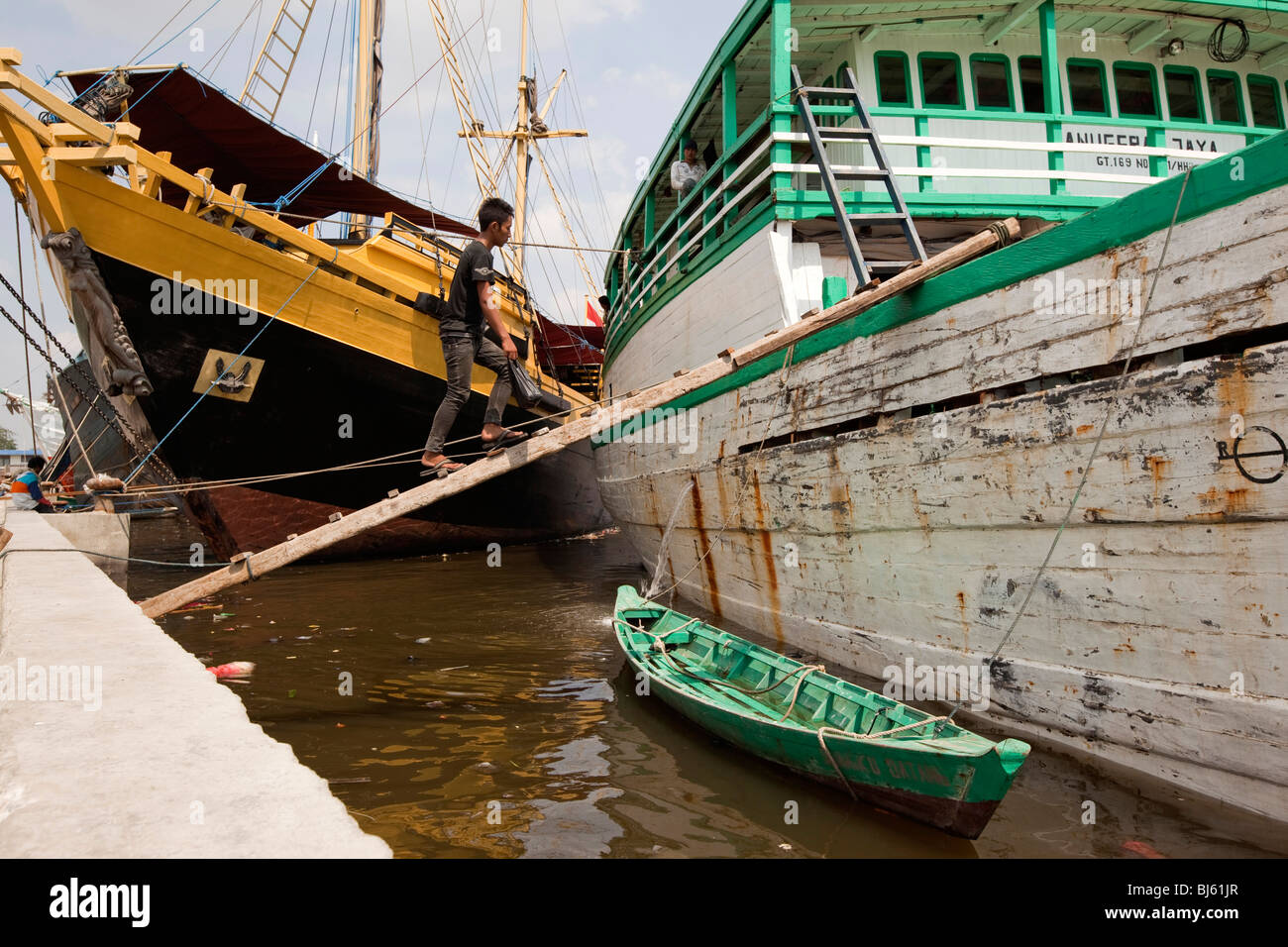 Indonesia, Java, Giacarta, Sunda Kelapa, lavoratore a piedi fino a vela in legno imbarcazione cargo gangplank Foto Stock
