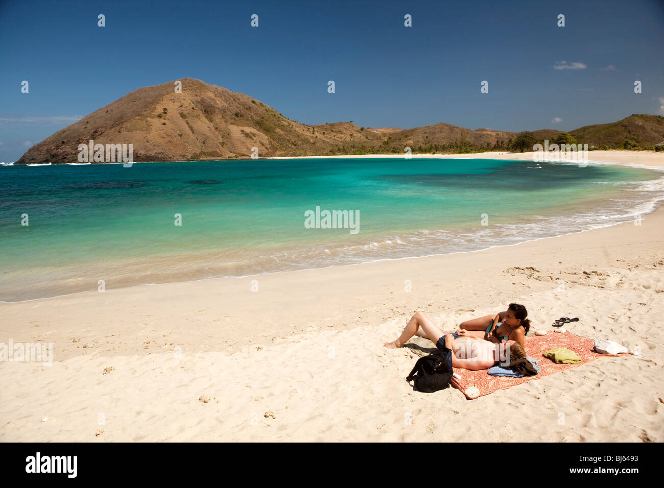 Indonesia, Lombok, South Coast, Mawun, spiaggia, razza mista western matura per prendere il sole Foto Stock