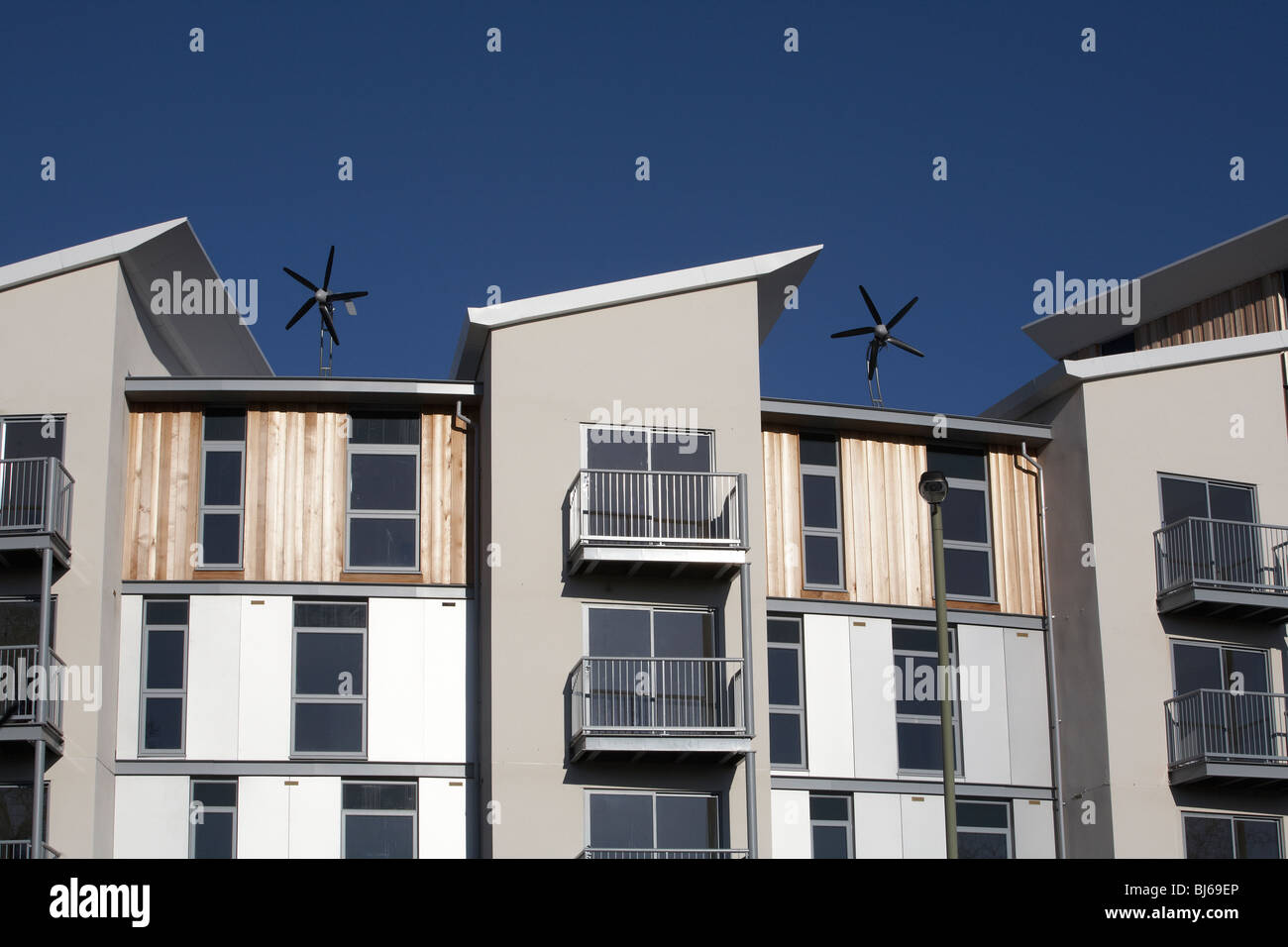 Le turbine eoliche sulla parte superiore di nuova costruzione appartamenti residenziali e appartamenti Foto Stock