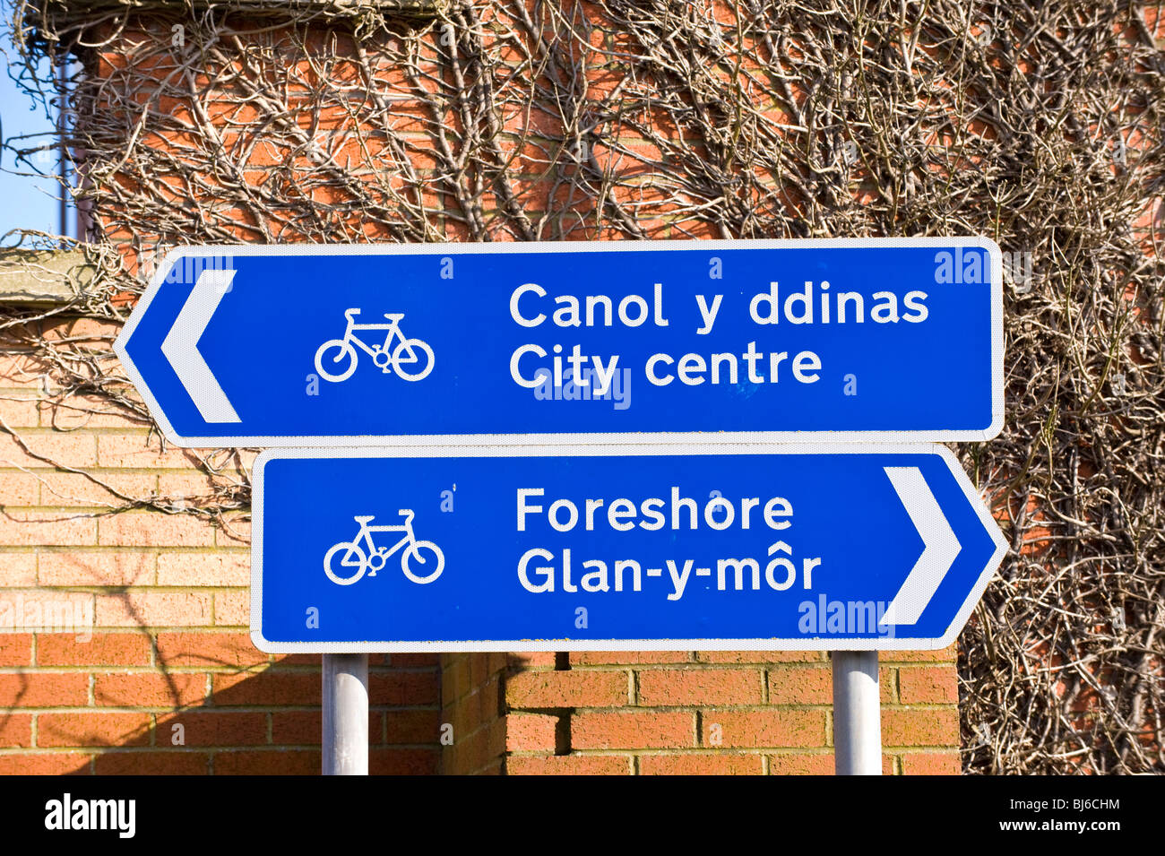 Welsh bilingue Lingua Inglese le indicazioni blu per cycleway dal centro città di FORESHORE a Swansea, South Wales, Regno Unito Foto Stock