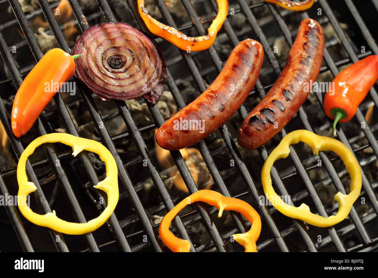 Salsicce, i peperoni e le cipolle sulla griglia Foto Stock