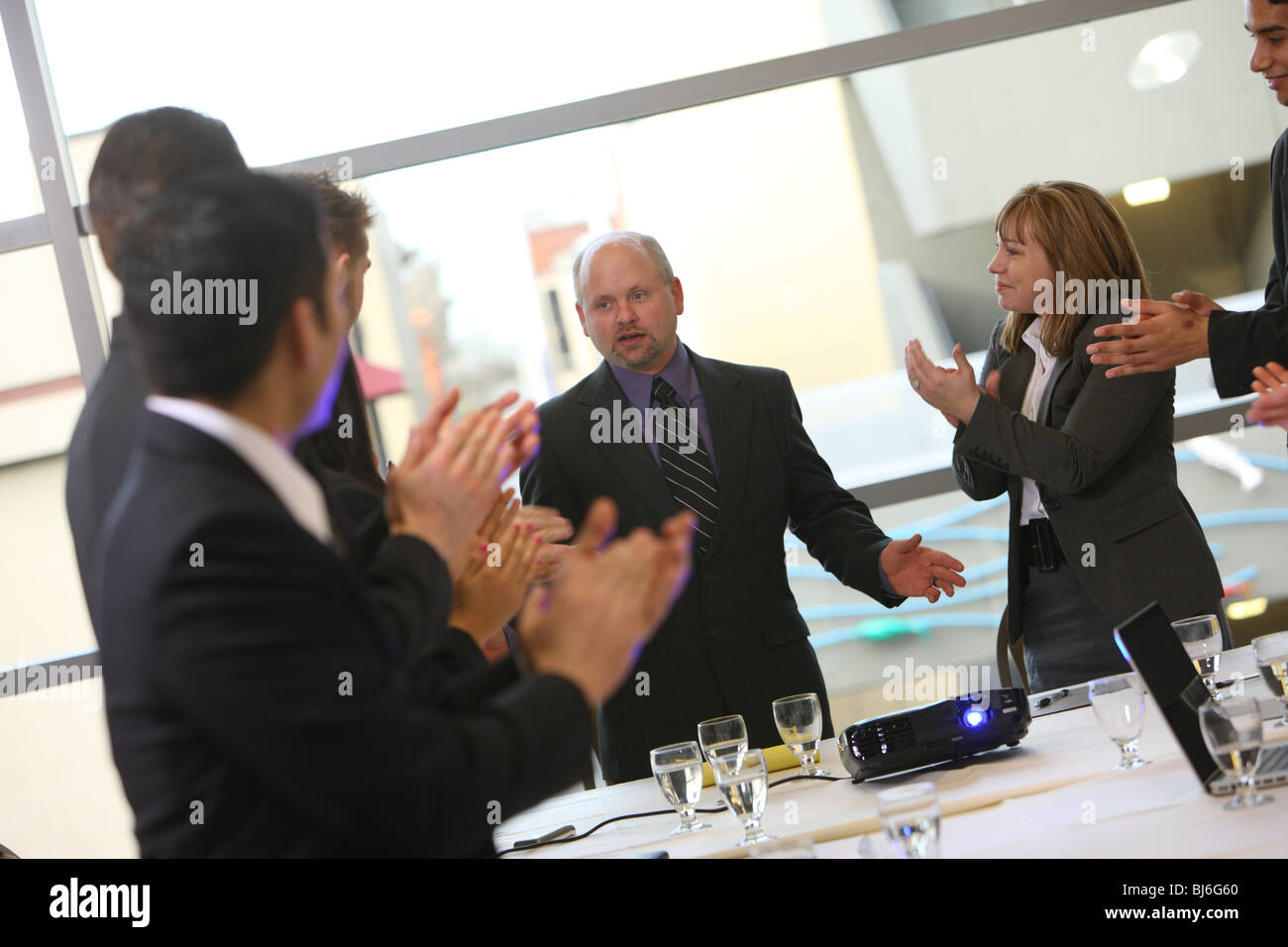 La gente di affari in board camera riunione clap per boss Foto Stock