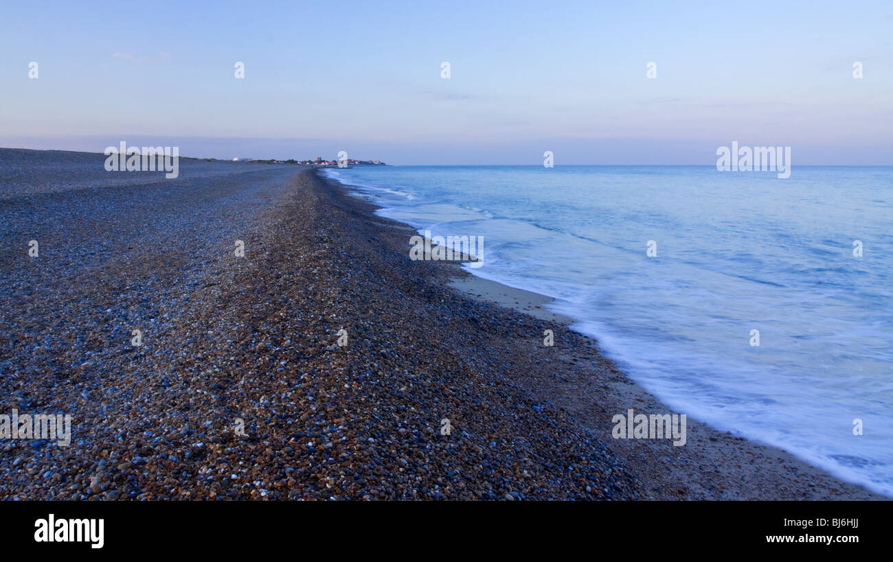 La linea di costa a Aldeburgh nel Suffolk East Anglia England fotografata al crepuscolo con ciottoli in primo piano Foto Stock