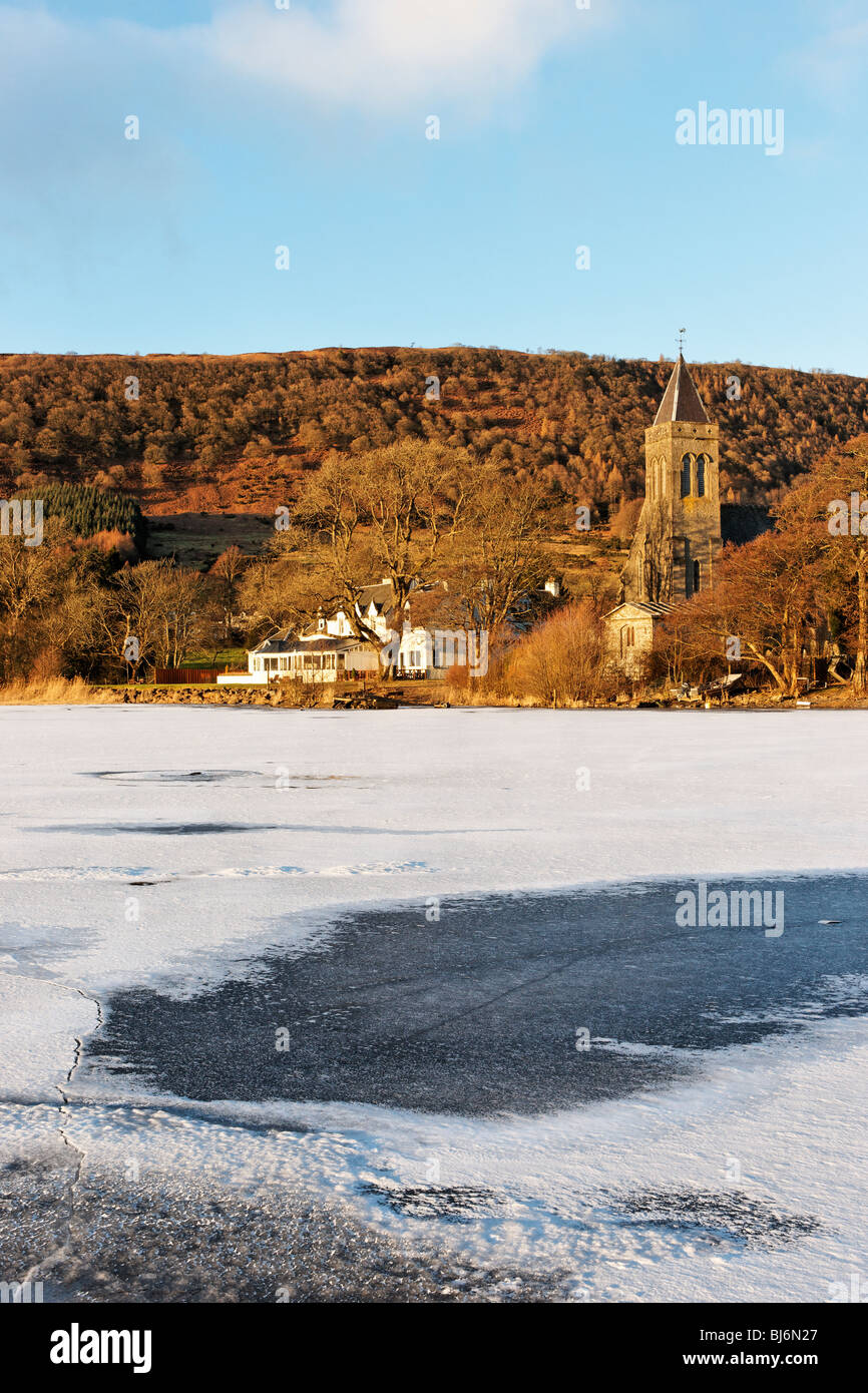 Il Lago di Menteith presso il porto di Menteith, Stirling, Scozia. Vista del lago Hotel e la Chiesa Parrocchiale. Foto Stock