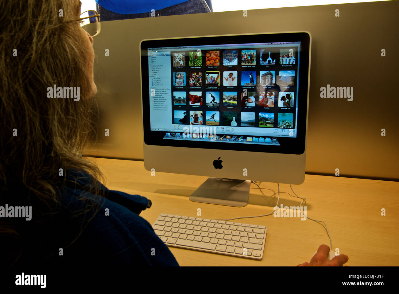 Donna in selective soft focus utilizzando iMac 21,5 pollici Apple dual core Intel computer presso la stazione di lavoro Foto Stock