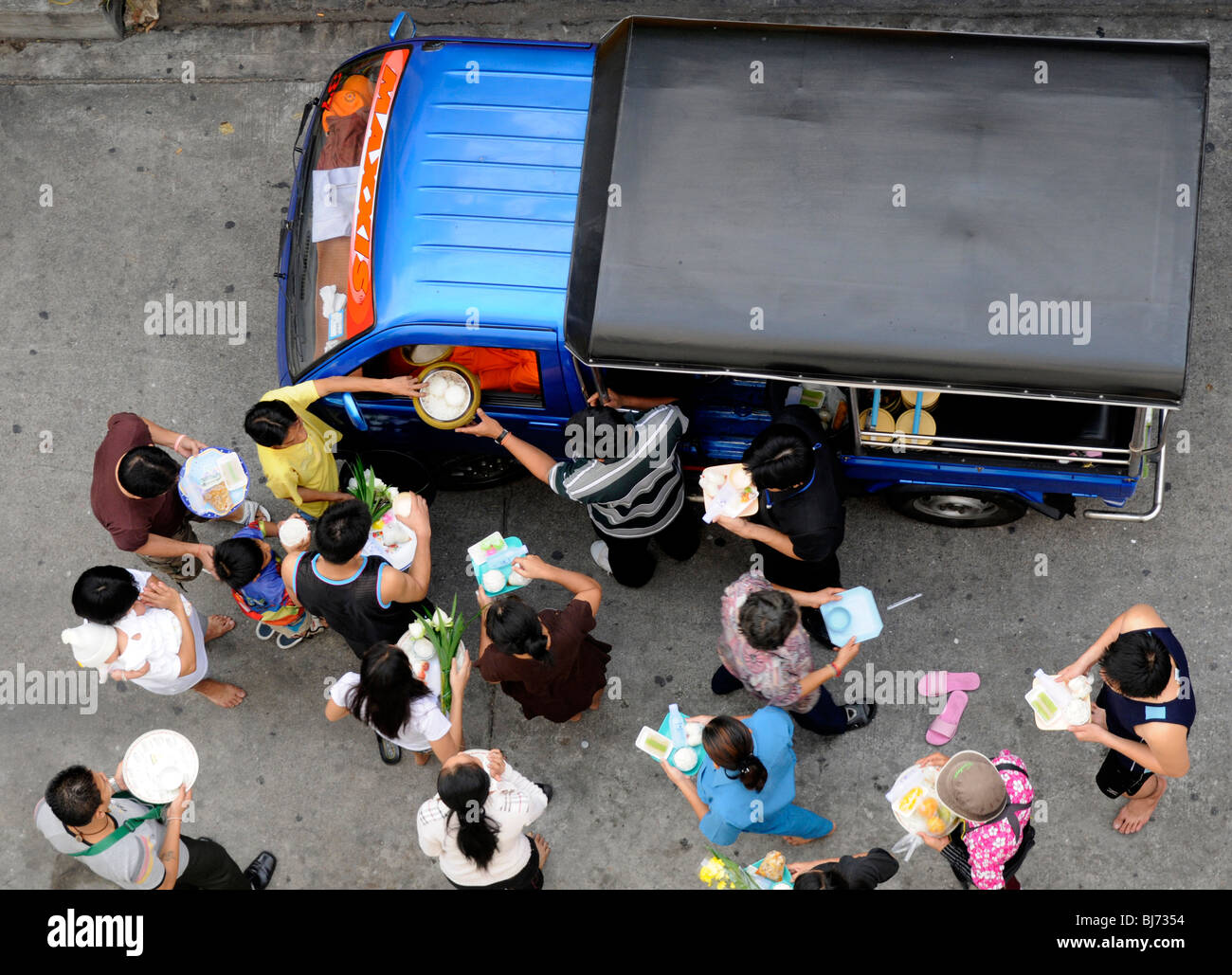Vista aerea di persone rendendo merito , disabili vecchio monaco è all'interno di pick up,nonthaburi , vicino a Bangkok , Thailandia Foto Stock