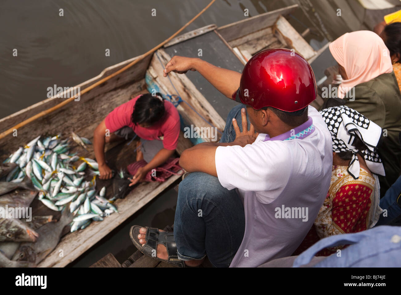 Indonesia Sulawesi, Kaledupa Isola, Ambuea village, il mercato locale del pesce donna Vendita di catture da parte di piccole barche da pesca Foto Stock