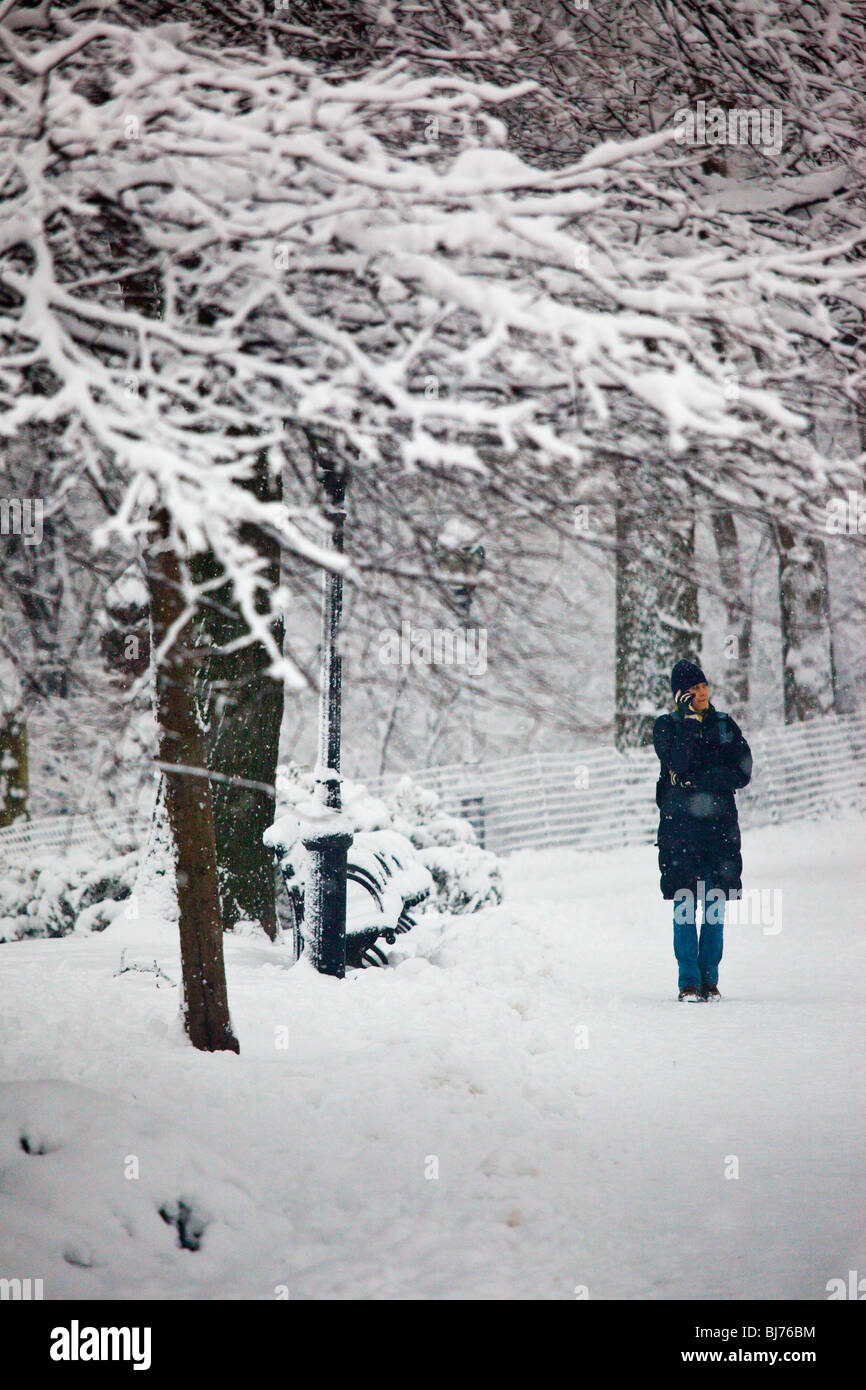 Giovane donna parlando sul suo cellulare, inverno, al Central Park di New York City Foto Stock