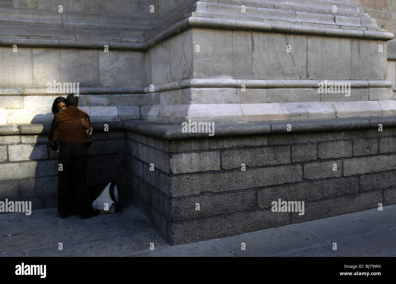 Un paio di abbracciare in un angolo della facciata esterna del Duomo di Milano, Milano, Italia Foto Stock