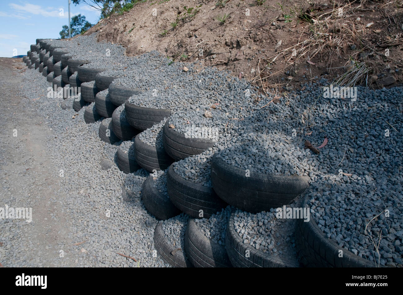 Pneumatici riciclati e ghiaia utilizzati come parete di ritegno su un vialetto Foto Stock