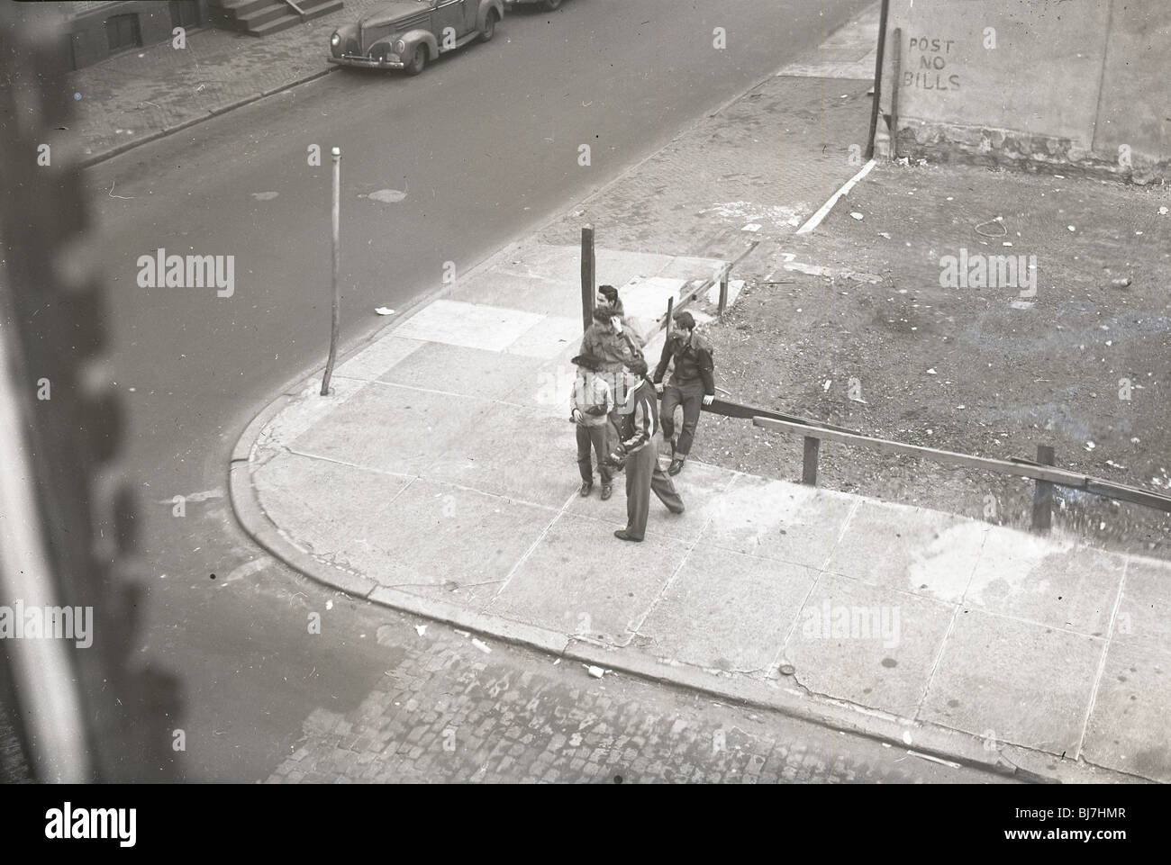 Gli uomini in piedi su un angolo di Philadelphia durante i primi anni cinquanta. Foto Stock