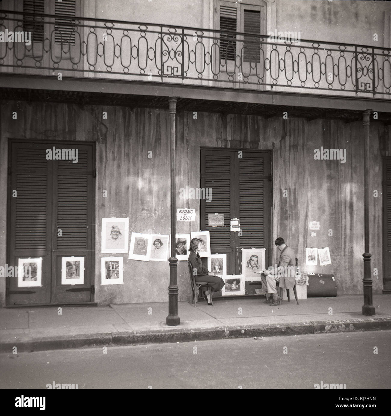 Un artista dipinge il ritratto di una donna su una strada di New Orleans French Quarter durante i primi anni cinquanta. arte artista street Foto Stock