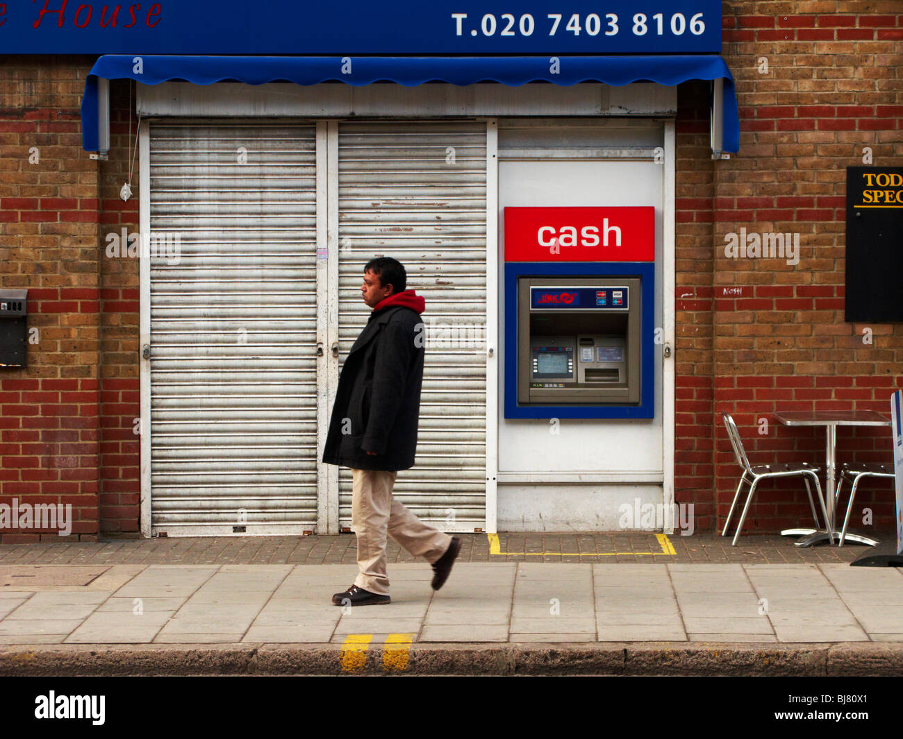 Un foro nella parete di cassa cassa della macchina da un borded fino il negozio nella East End di Londra Foto Stock