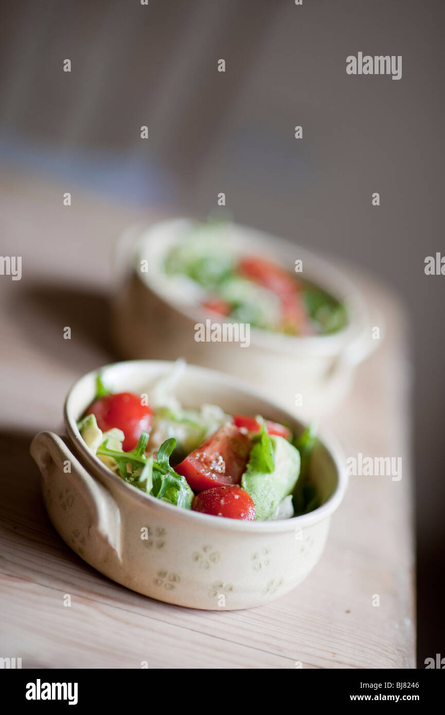 Una dieta mediterranea di pomodoro fresco e lattuga con olio di oliva insalata in un rustico vaso in ceramica. Foto Stock