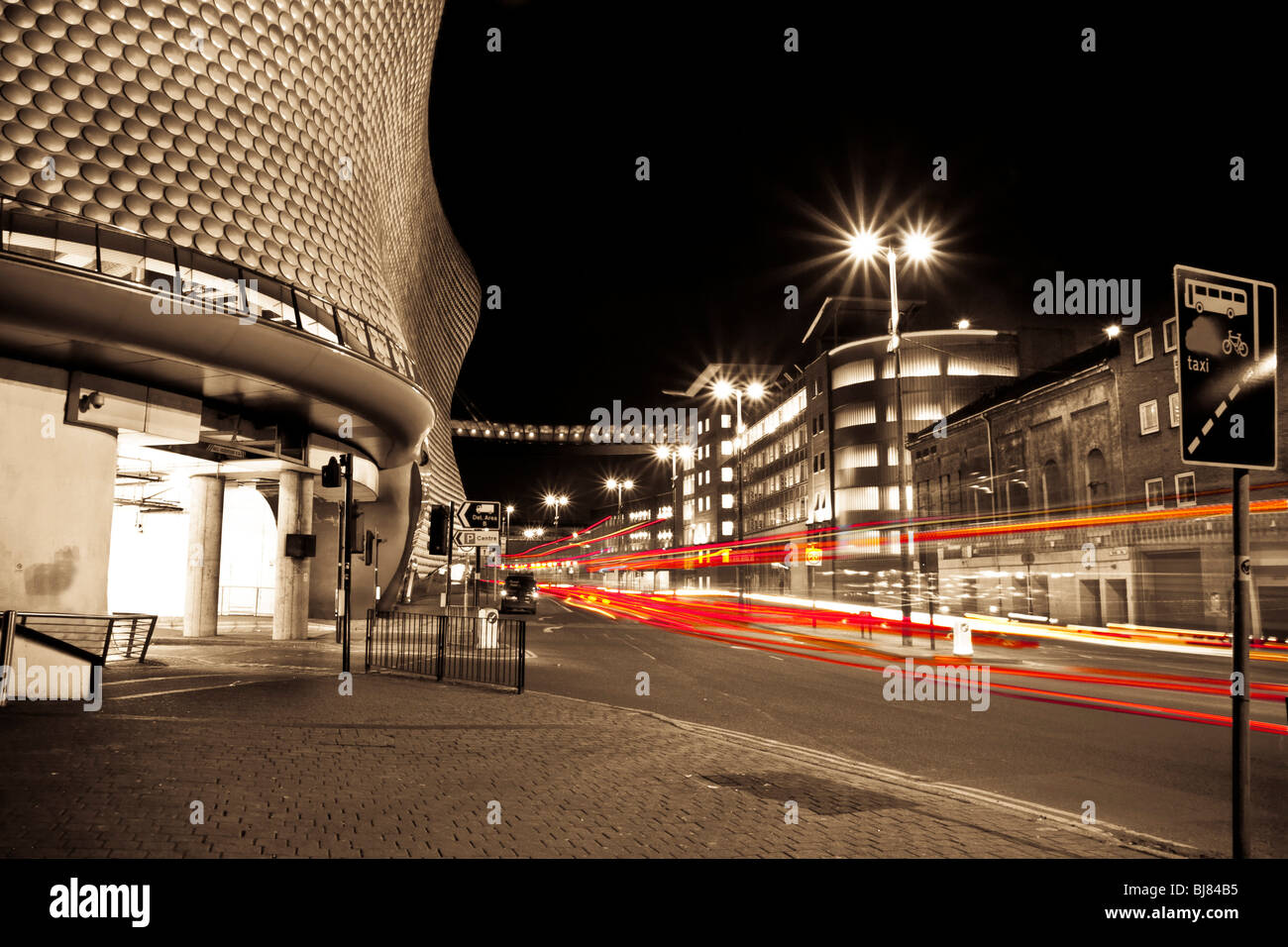 Il traffico lascia sentieri di luce passato selfridges nel centro della città di Birmingham di notte. Foto Stock