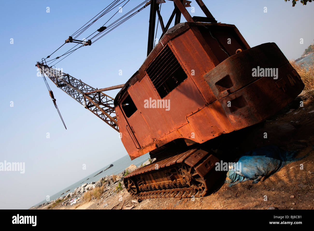 India Kerala, Mahe (Pondicherry) il territorio dell' Unione, old arrugginimento gru sulla scogliera rocciosa le difese costiere Foto Stock