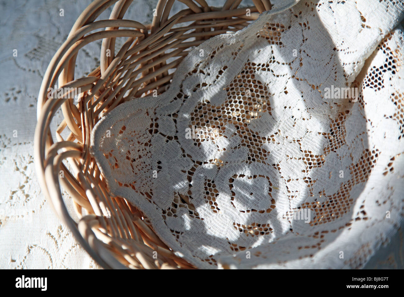 Mano cesto tessuto & antique Pizzo sono una bella vista in inizio di mattina di sole creando le forme insolite e drammatico artistico ombra Foto Stock
